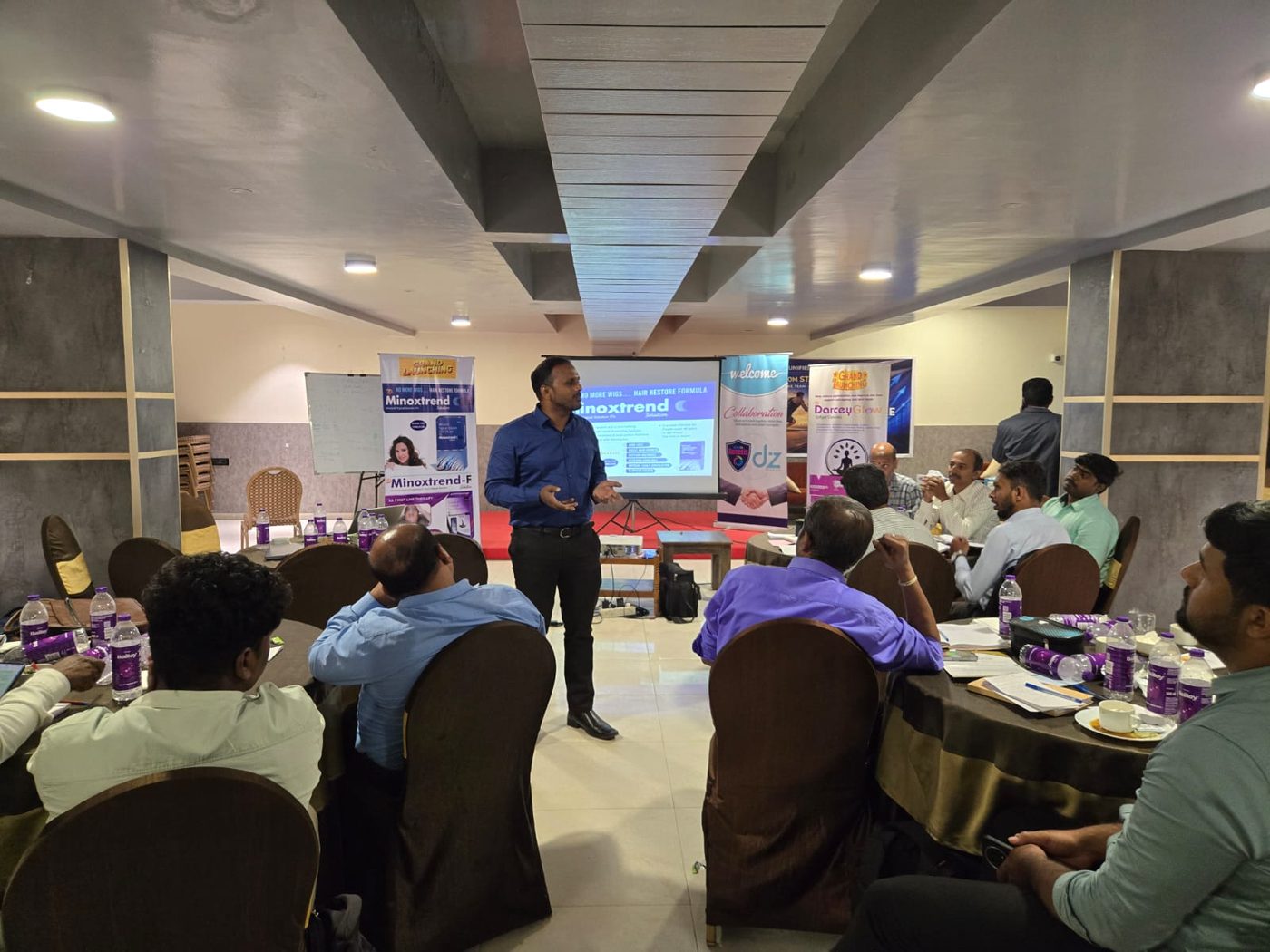 Attendees seated at tables during a product presentation